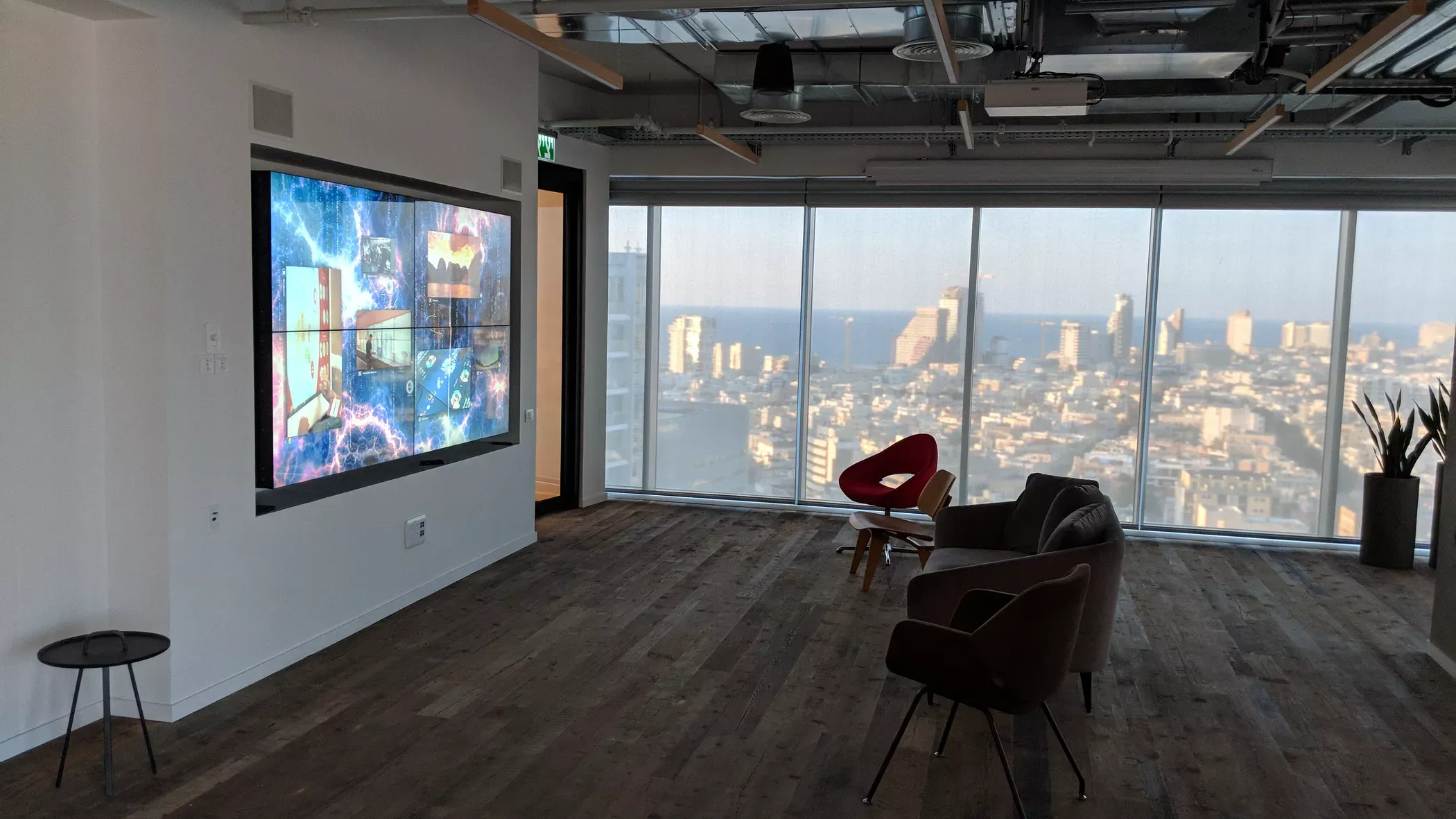 Videowall in a Tel Aviv consulting firm’s meeting room, floor-to-ceiling skyline glazing behind